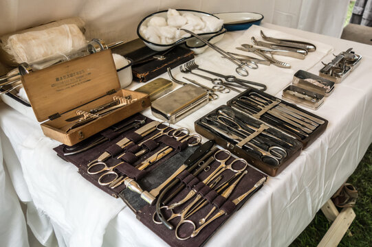 Set of surgical instruments and tools on a white cloth table, historical reconstruction
