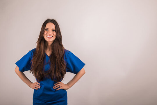 Portrait Of Nurse In Blue Uniform Looking At Camera On Light Studio Background