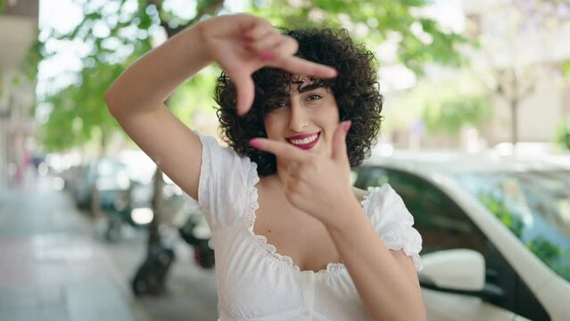 Young middle east woman smiling confident doing photo gesture with hands at street