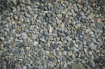 Smooth background with a pebble texture. Pebble sea beach close-up, dark wet pebbles and gray dry pebbles. High-quality photography