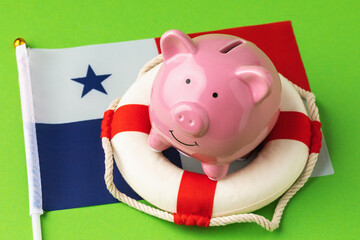 Piggy bank, lifebuoy and flag on a blue background, the concept of saving the Panama economy