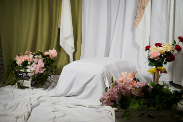 White bed in a classic style with flowers. Hotel's room. The spring location for photo shoot in studio
