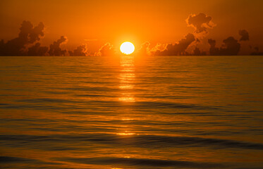 Sun rising above calm ocean