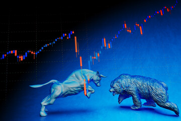 Stock chart and blue painted bull and bear sculpture staring at each other in dramatic contrasting light representing financial market trends under blue background. Concept 3D CG of stock market.