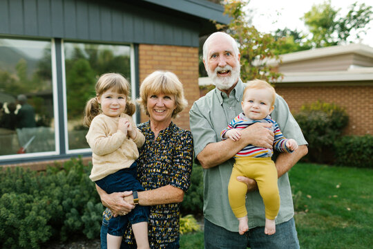 Portrait Of Smiling Grandparents With Grandchildren (2-3, 4-5) In Back Yard