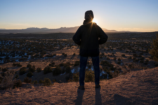 USA, New Mexico, Lamy, Rear view of man in desert landscape at sunset in Galisteo Basin Preserve