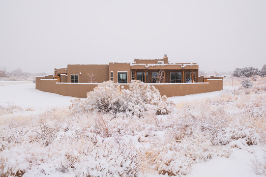 USA, New Mexico, Santa Fe, Pueblo style house in snow covered landscape