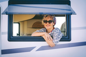 Portrait of young woman smiling at the camper van window. Happy tourist enjoy travel vanlife...