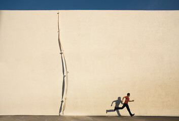 Man escaping by climbing rope over wall