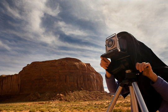 USA, Utah, Monument Valley, Man photographing desert with vintage camera