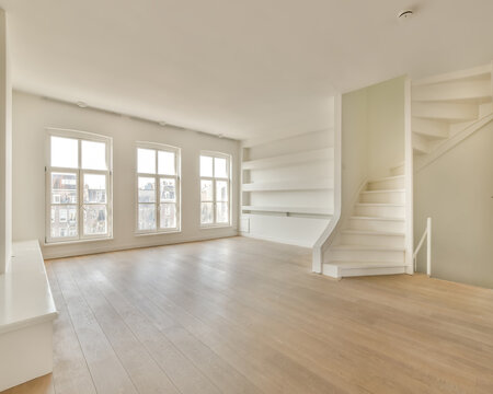 Living room with stairs on parquet floor at home in sunlight