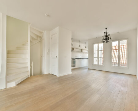 Living room with stairs on parquet floor at home in sunlight