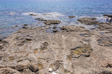 Small shallow sea creek with stones under the sun
