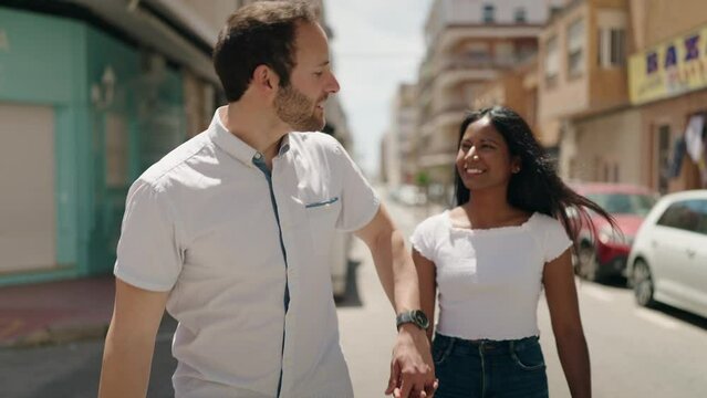 Man and woman interracial couple holding in arms at street