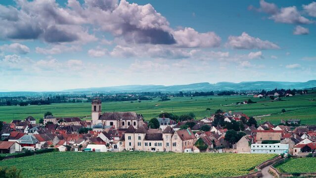 Time lapse of clouds moving over summer vineyards landscape and village Pommard. Burgundy road. Cote de Beaune, Cote d'Or, France.