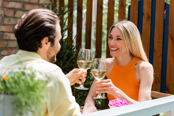 Romantic couple toasting with wine in outdoor cafe.