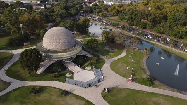 drone flight flying over the planetario park in buenos aires in orbit with the building showing the palermo lakes and busy highway in the background
