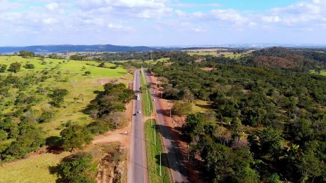 A scenic highway through the green summer countryside - pull back aerial view
