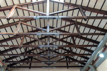 Wooden ceiling structure. Beams with bolts and metal joints