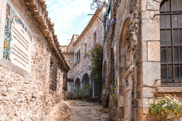 Narrow alley with old stone wall buildings in Spain. Facade of medieval buildings