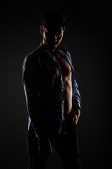 Fototapeta na wymiar Male model posing in a light dimmed room
