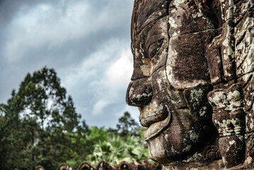 A large figure carved face on sandstone in the pagoda of Bayon Angkor Thom Temple, Siem Reap,...