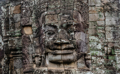 A large figure carved face on sandstone in the pagoda of Bayon Angkor Thom Temple, Siem Reap, Cambodia.