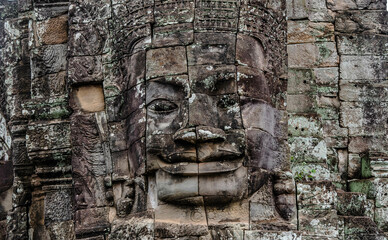 Fototapeta premium A large figure carved face on sandstone in the pagoda of Bayon Angkor Thom Temple, Siem Reap, Cambodia.