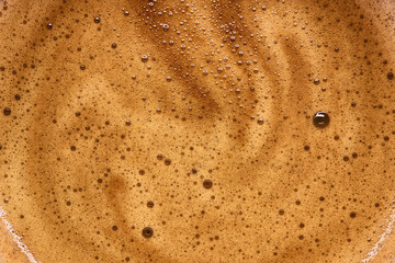 Macro shot of coffee milk foam. Background texture of espresso, coffee cream.