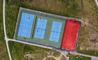 Aerial view looking down onto tennis courts and a basketball court. 