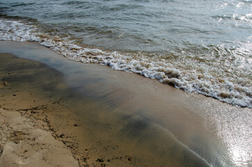 Traces of waves on the sand. The waves wash over the sandy beach.