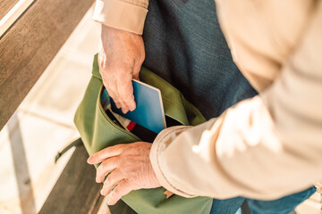Close-up image of woman putting covid-19 passport in pocket of backpack. Vacation travel adventure trip concept.