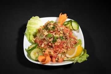 Nutritious simple salad plate with green vegetables, walnuts, onions and oil, top view, space for text