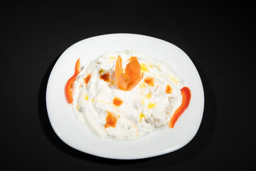 Traditional Arabian eggplant dish Baba Ghanoush with olive oil and herbs in white yogurt. isolated on black background. Close