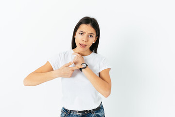 Dissatisfied young woman points at the clock with claim