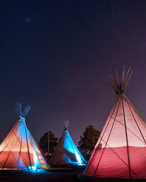 Teepees glowing under a starry sky at night in Marfa, Texas