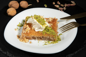 Turkish dessert kunefe, kunafa, kadayif with pistachio powder and cheese, served hot, very sweet. Turkish traditional dessert.Lebanese dessert of Kunafa isolated on white.