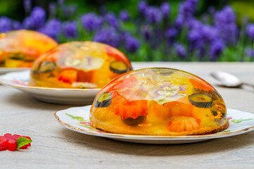 Lemon jelly globes with fresh fruit, edible flowers and gold flakes on pistachio biscuit - gourmet dessert