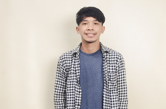 Close Up Portrait Of Young Asian Male Model With Short Black Hair Wearing Plaid Shirt Standing Smiling On Isolated Background