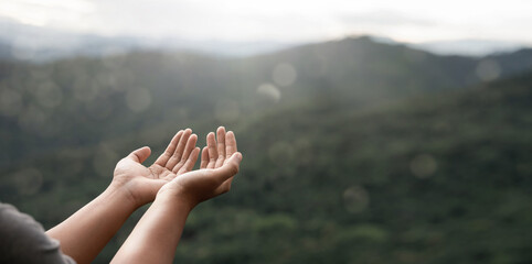 The two hands of a young man who prayed for hope from God Praise God concept. Pray, communicate. Mountain nature background. at sunrise