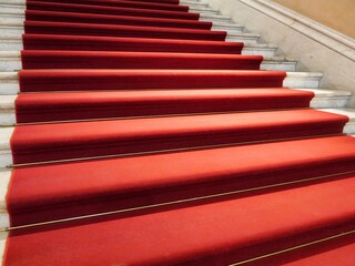 Classic elegant marble staircase with red carpet