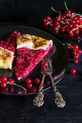 Red currant pie from recipe of Berry Galette with cut slices and vintage cake forks - dark and moody