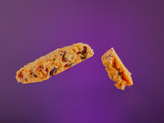 Cranberry granola slice on a purple gradient background.