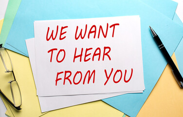 We Want To Hear From You text on paper on colorful paper background