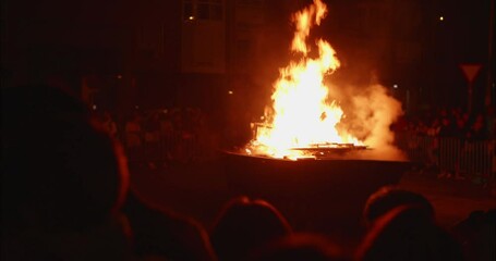 People gathering around a bonfire celebrating La Noche de San Juan in Madrid