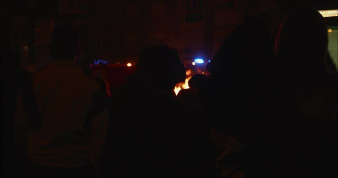 People gathering around a bonfire celebrating La Noche de San Juan in Madrid