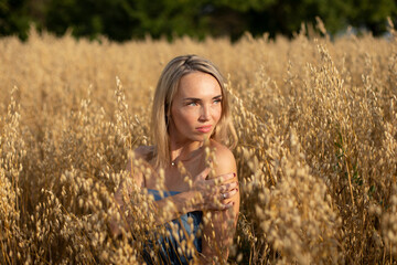 Portrait of a blonde young girl in the Ukrainian field of wheat