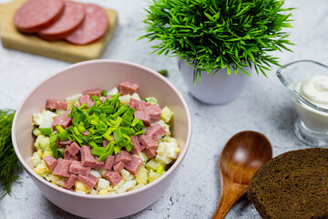 Okroshka - russian national food with meat, potato, kvass or kefir, radish and parsley on white background
