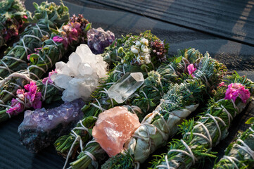 Smudge sticks and crystals on a black wooden table