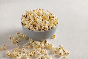 A bowl of delicious popcorn on a light background